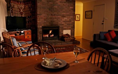 a living room with a table and a fireplace at Absolute Beachfront Mollymook in Mollymook