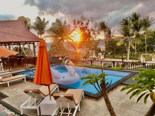 a pool at a resort with a swan and a float at Surya Chandra Beach Bungalow in Nusa Penida