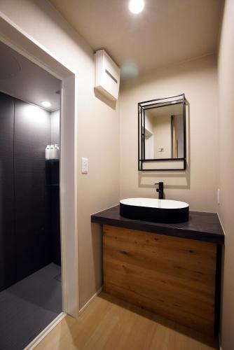 a bathroom with a sink and a mirror at Koti Sopo Universal Bay 1 by Liaison in Osaka
