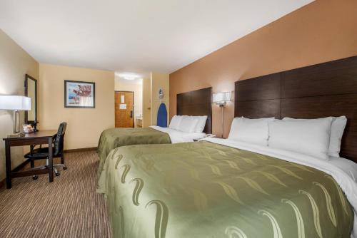a hotel room with two beds and a desk at Quality Inn & Suites Brandenburg - Fort Knox in Brandenburg