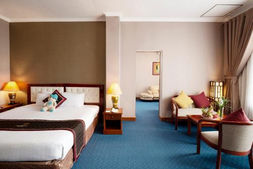 a hotel room with two beds and a couch at Grand Hotel Vung Tau in Vung Tau