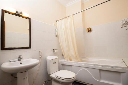 a bathroom with a toilet and a sink and a mirror at Grand Hotel Vung Tau in Vung Tau