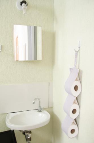 a bathroom with a sink and a toilet paper roll holder at Pousada Happy Inn in Campinas