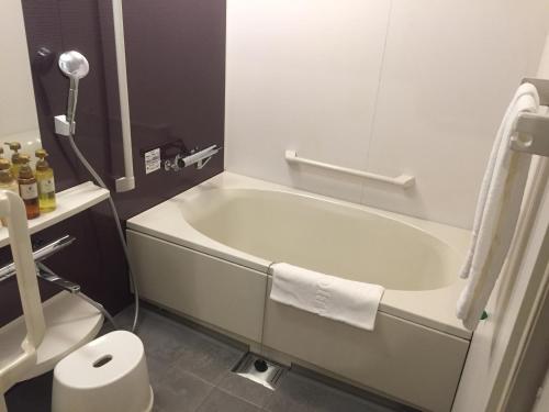 a white bath tub sitting next to a white toilet at HOTEL MYSTAYS Kamata in Tokyo