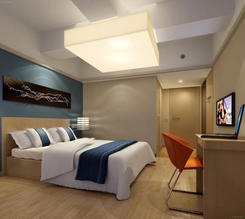 um quarto com uma grande cama branca e uma televisão em Nanjing Lafei Hotel Lukou Airport Branch em Nanquim