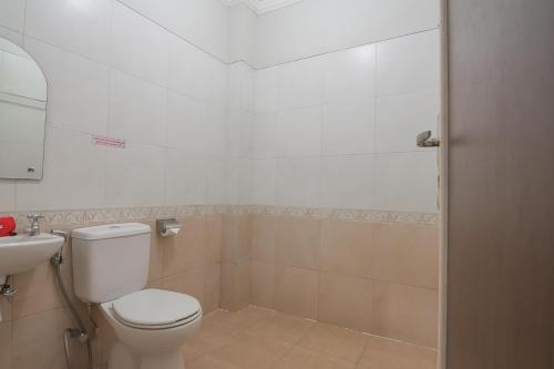 a bathroom with a toilet and a sink at RedDoorz Plus Syariah at Banjarbaru 2 in Banjarbaru