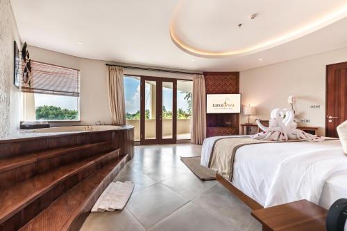 a hotel room with two beds and a bathtub at tanadewa Resort Ubud Bali by Cross Collection in Ubud