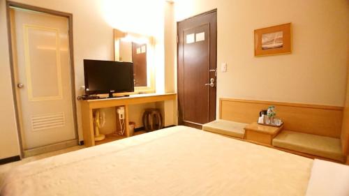 a hotel room with a bed and a television at Yes Hotel in Chiayi City