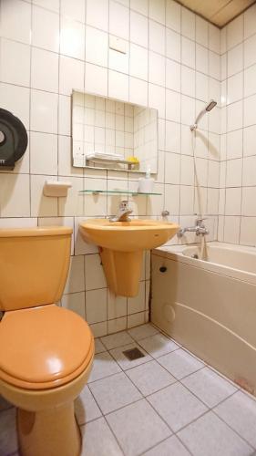 a bathroom with a toilet and a sink and a tub at Yes Hotel in Chiayi City