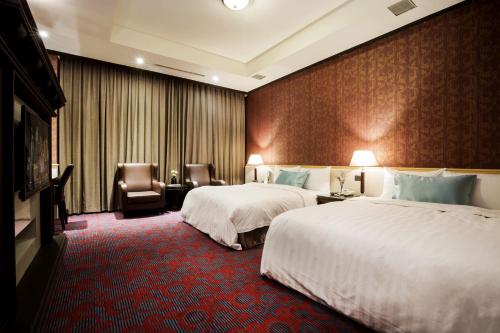 a hotel room with two beds and two chairs at Duo Romance Hotel in Hualien City