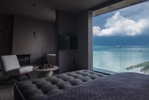 a bedroom with a large window with a view of the ocean at Yakamoz Erhai Hotel in Dali