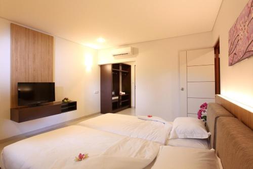 a hotel room with two beds and a couch at Mi Casa Residence in Seminyak