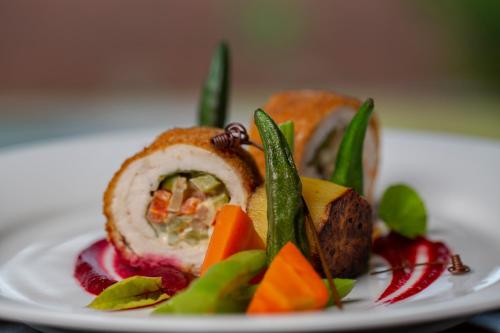 a white plate with a sandwich with vegetables on it at Roo Mansala Boutique Villas in Sigiriya