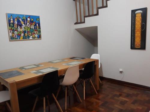 a dining room table with chairs and a painting on the wall at Casa Vermelha in Ouro Preto