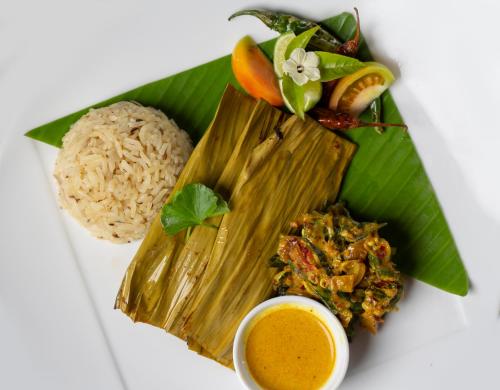 a plate of food with rice and vegetables on it at Roo Mansala Boutique Villas in Sigiriya