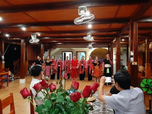 Mai Chau Dreams Homestay في ماي تشاو: مجموعة من الناس واقفين في غرفة