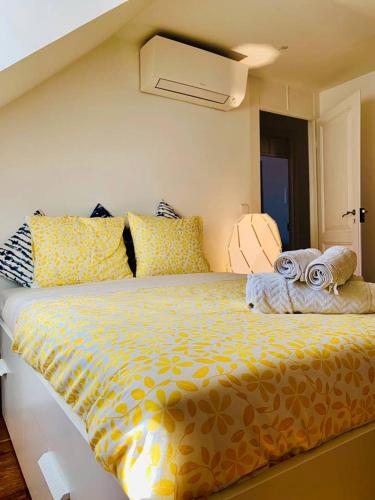 a bedroom with a large bed with a yellow comforter at Best Apartment in Paços de Arcos in Paço de Arcos