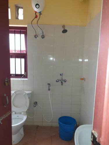 uma casa de banho com um WC e um chuveiro em Shantiniketan Bungalow em Bolpur