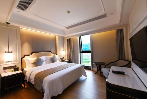 a hotel room with a bed and a large window at Ramada Plaza by Wyndham Wenzhou in Wenzhou