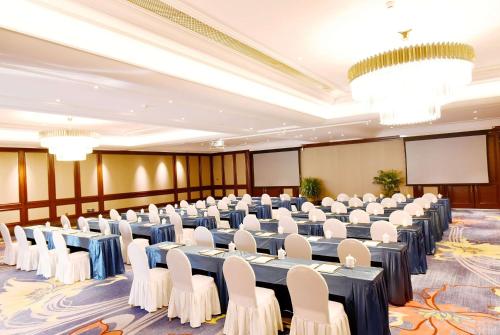 a large room with tables and chairs and a screen at Ramada Plaza by Wyndham Wenzhou in Wenzhou