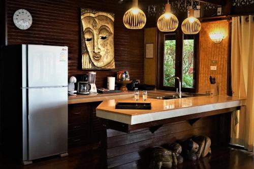 uma cozinha com um frigorífico branco e um lavatório em The Natives Samui em Ban Bang Po