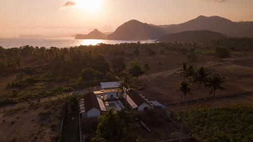 an aerial view of a house on the beach with the sunset at Suku Lifestyle Hotel & Villas in Selong Belanak