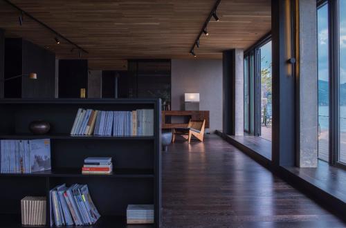 a living room with a book shelf and a table at Yakamoz Erhai Hotel in Dali