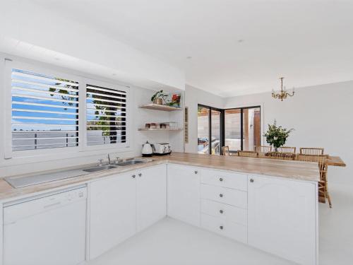 a white kitchen with white cabinets and a window at 10 OCEAN VILLA in Port Fairy