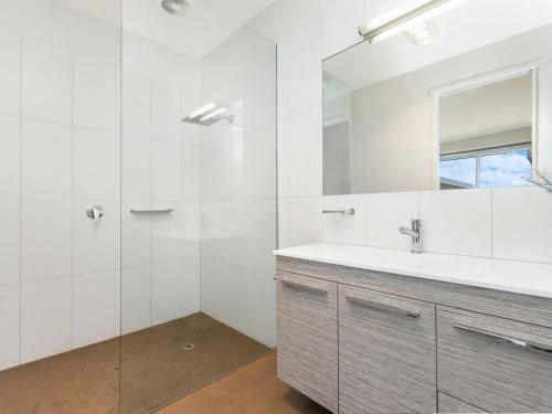 a white bathroom with a sink and a mirror at 38 Oceane in Port Fairy