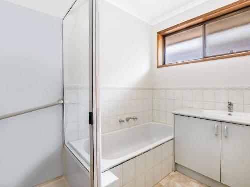 a bathroom with a bath tub and a sink at 45 on REGENT in Port Fairy