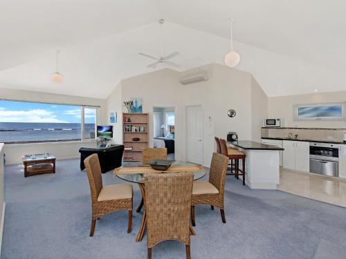 Una cocina y una sala de estar con mesa y sillas. en A Top Deck, en Port Fairy