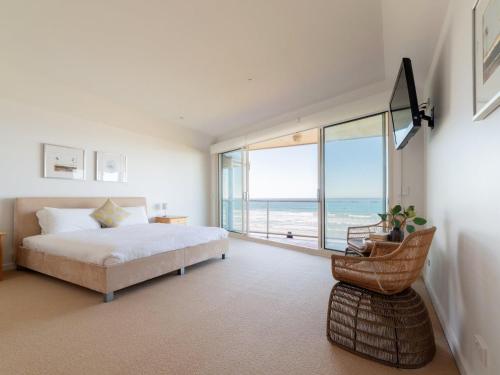 a bedroom with a bed and a view of the ocean at Bayview Beachfront Apartment in Port Fairy