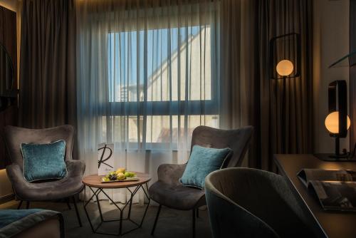 a room with chairs and a table and a window at Rosslyn Central Park Hotel Sofia in Sofia