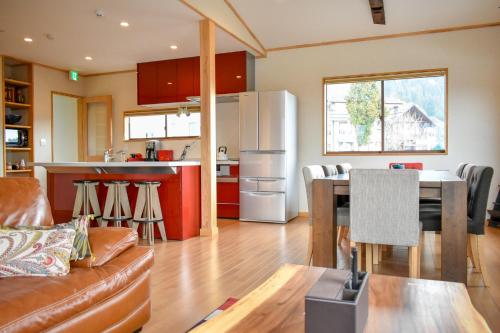 a kitchen and living room with a refrigerator and a table at Holiday Home Nozawa in Nozawa Onsen