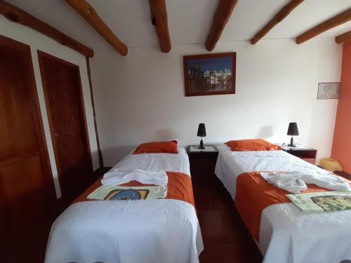 three beds in a room with white walls at Suymar Ecolodge Galapagos in Puerto Ayora
