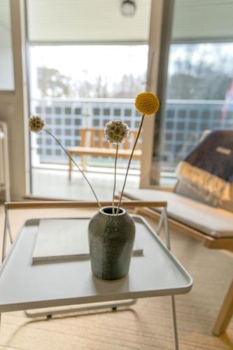 a vase with flowers on a table in a living room at Hotel GSH in Rønne