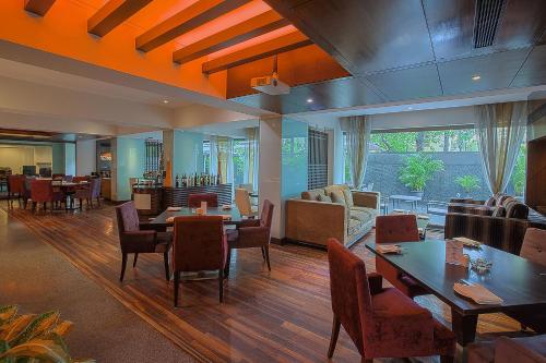 a restaurant with tables and chairs and a living room at Oakwood Residence Naylor Road Pune in Pune