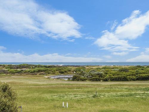 Un campo de hierba con el océano al fondo en Bella On Victoria, en Port Fairy