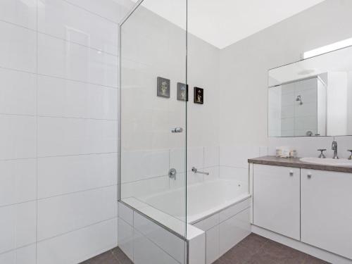 a white bathroom with a shower and a sink at Blue Vista in Port Fairy
