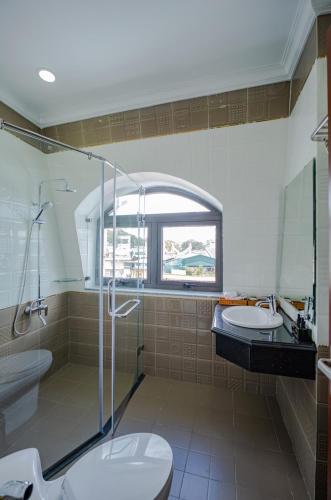 a bathroom with a shower and a toilet and a sink at Win Hotel Đà Lạt in Da Lat