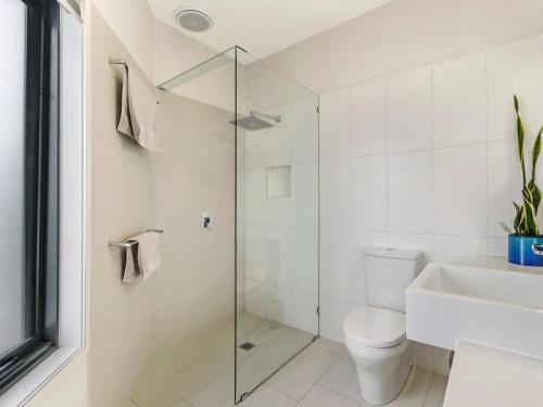 a bathroom with a shower and a toilet and a sink at Chimneys On Bank in Port Fairy