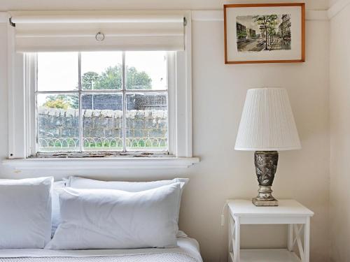 a bedroom with a window and a bed with white pillows at Dingle On Barclay in Port Fairy