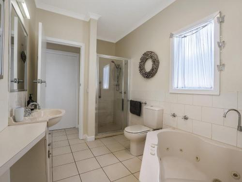a bathroom with a tub and a toilet and a sink at Gipps Getaway in Port Fairy