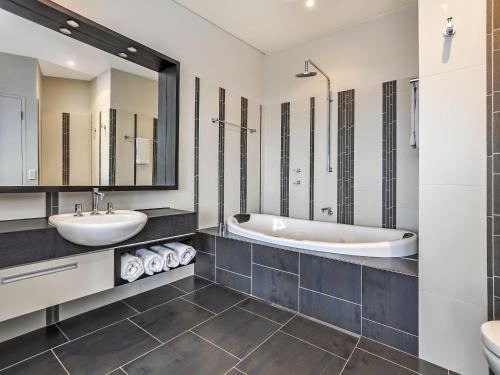 a bathroom with two sinks and a tub at Hearns Beachside Villa 2 in Port Fairy