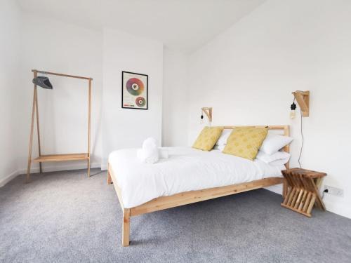 - une chambre avec un lit doté de draps blancs et d'oreillers jaunes dans l'établissement Railway Street by Switchback Stays, à Cardiff