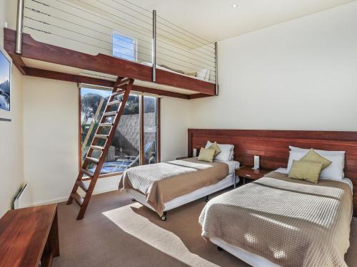 1 dormitorio con 2 camas y 1 cama elevada en Hearns Beachside Villa 4, en Port Fairy