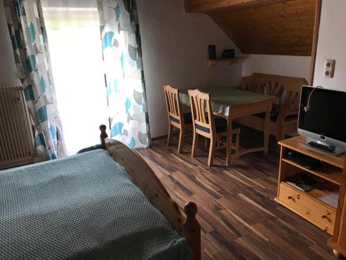 Habitación con cama, mesa y TV. en Wagnermoosgut en Bad Ischl