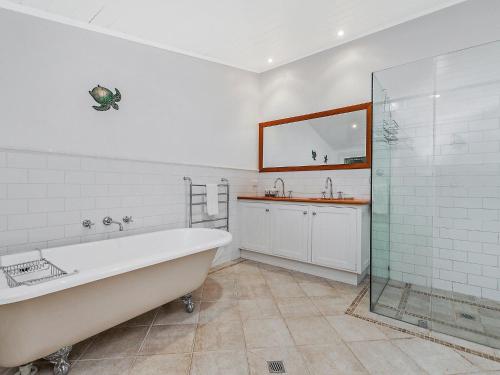 La salle de bains blanche est pourvue d'une baignoire et d'un lavabo. dans l'établissement Hillingden, à Port Fairy