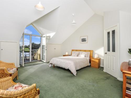 a bedroom with a bed and a large window at Johanssons Perch 1 in Port Fairy