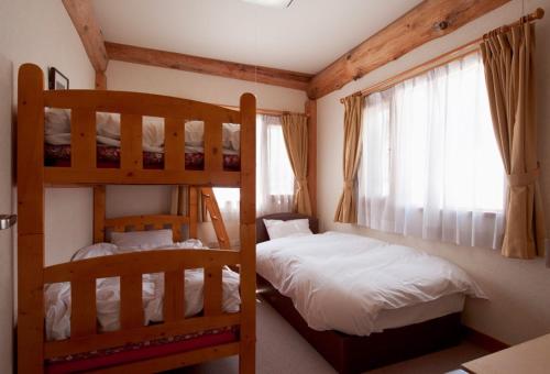 a bedroom with two bunk beds and a window at Silver Birch in Niseko